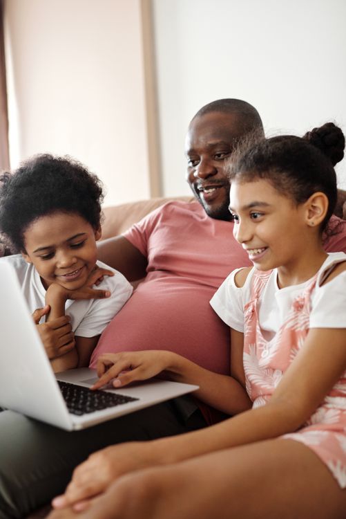 Happy family gathered around a laptop at home, enjoying fast internet connectivity